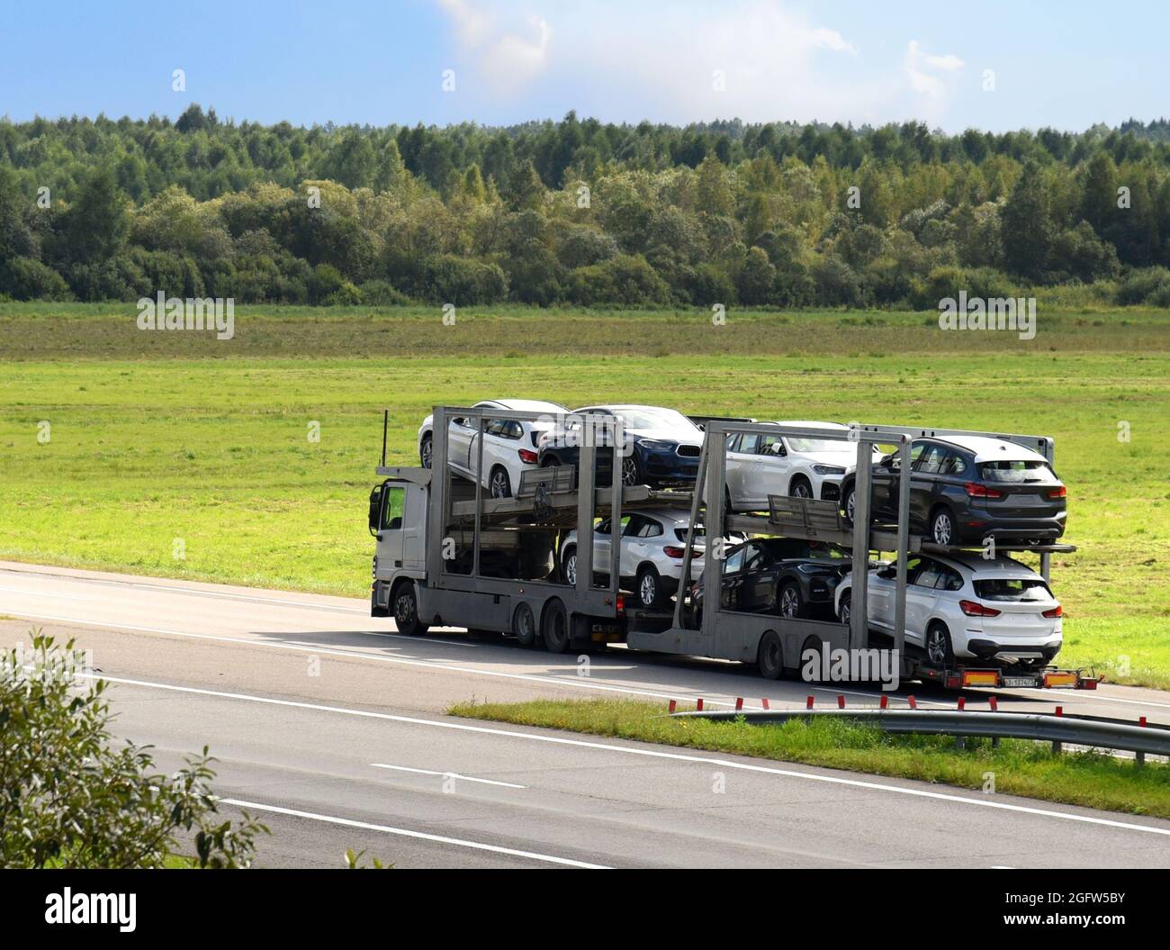 Car carrier trailer transports cars on highway. Auto transport and car  shipping services concept. Truck with Semi-remorque. Cars transporter and  shipp Stock Photo - Alamy