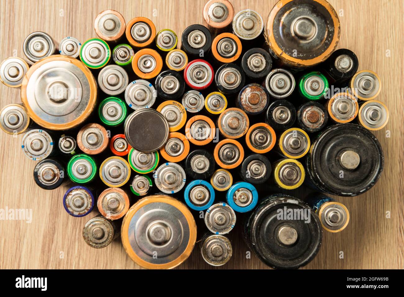 Flat batteries placed neatly on a wooden table. Concept of recycling and care for the environment. Stock Photo