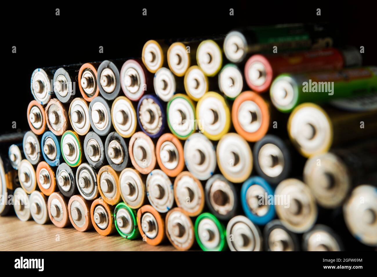 Flat batteries placed neatly on a wooden table. Concept of recycling and care for the environment. Stock Photo