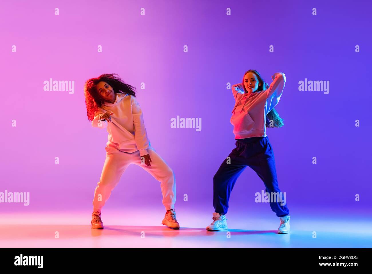 Two beautiful young girls dancing hip-hop in stylish clothes on ...
