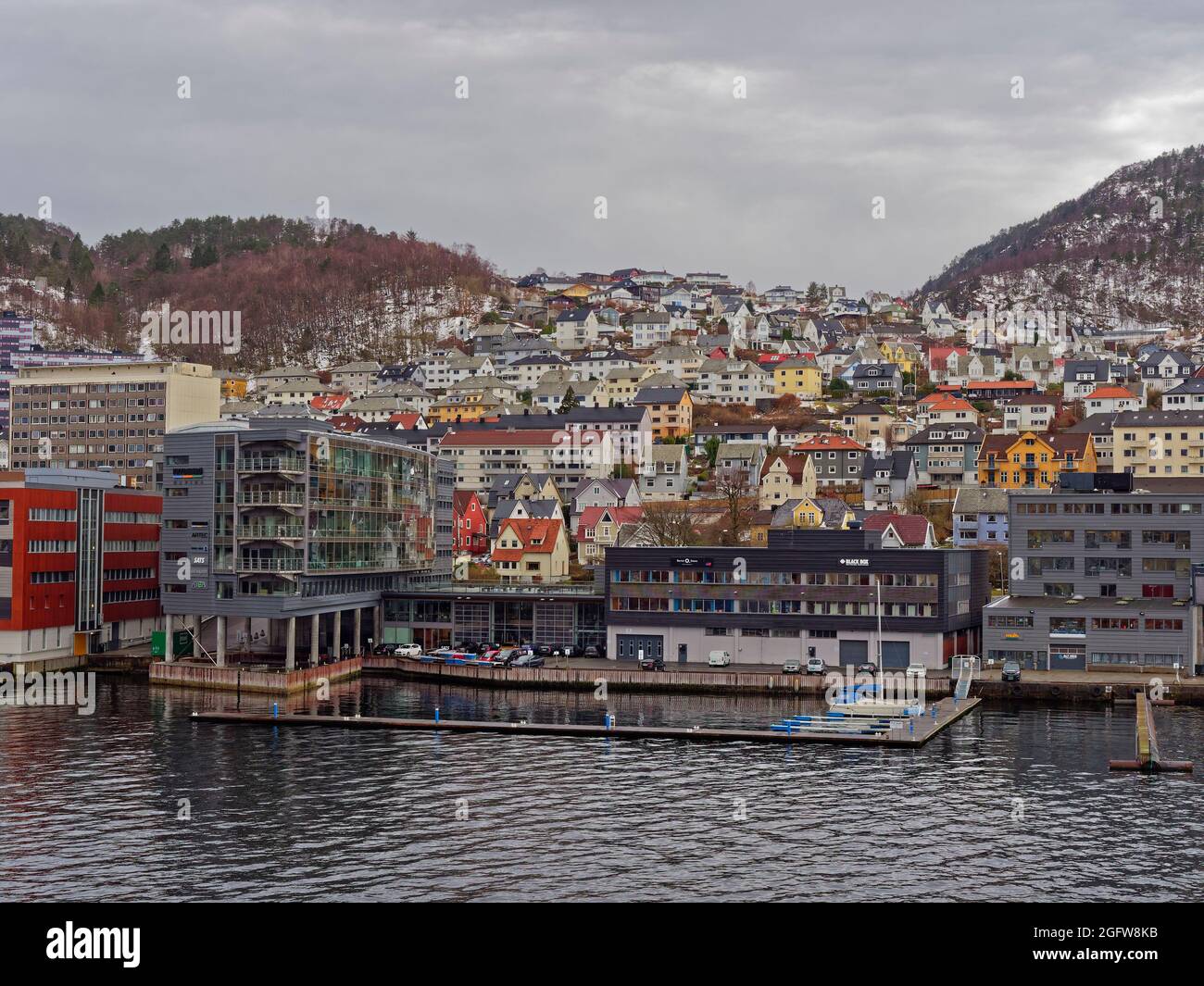 Apartments, Houses and Maritime Buildings all mixed up with one another on the waterfront of Bergen Port on a wintry day in April. Stock Photo