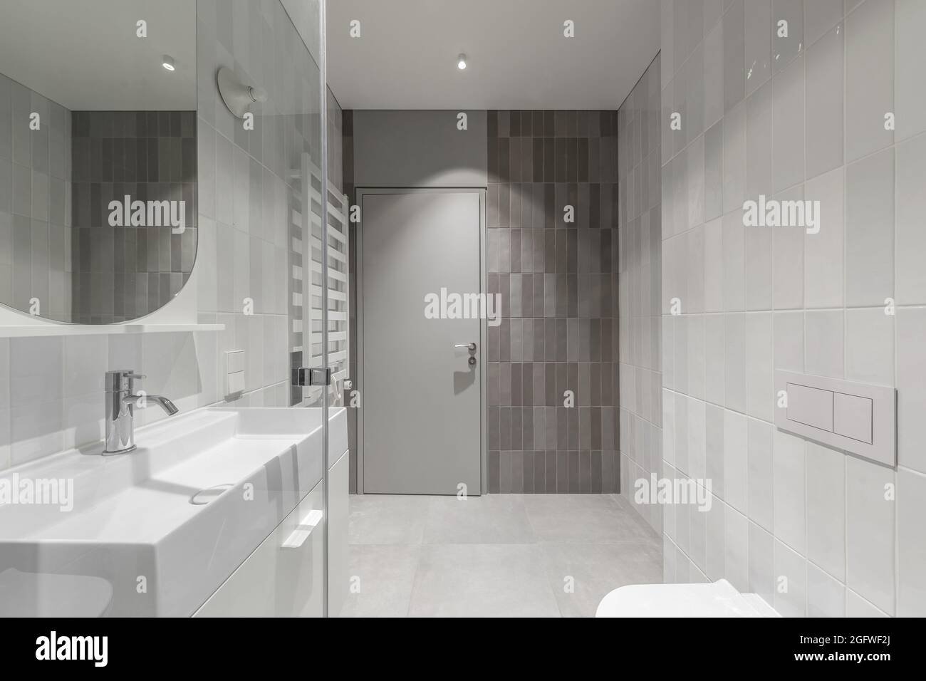 Modern furnished  minimalist bathroom light grey interior design with metro style grey tiles Stock Photo