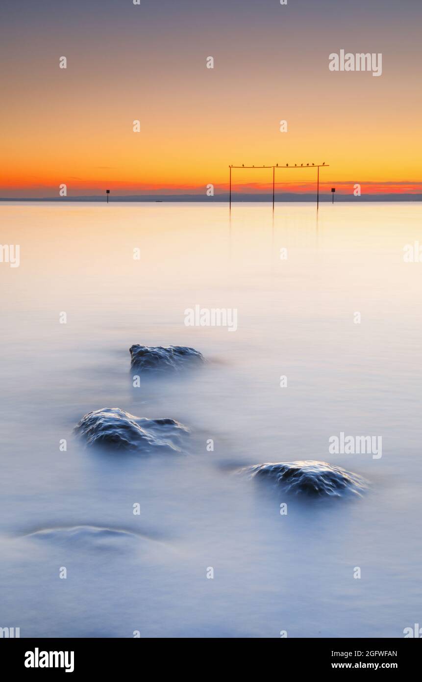 view from Arbon over Lake Constance at sunrise with stones in the foreground, Switzerland Stock Photo