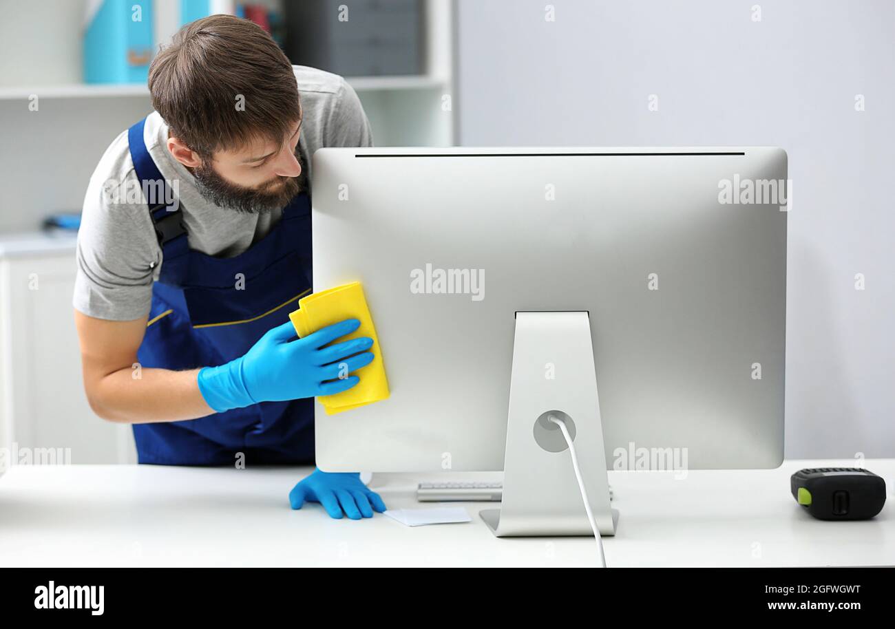 Funny young man wiping computer in office Stock Photo Alamy