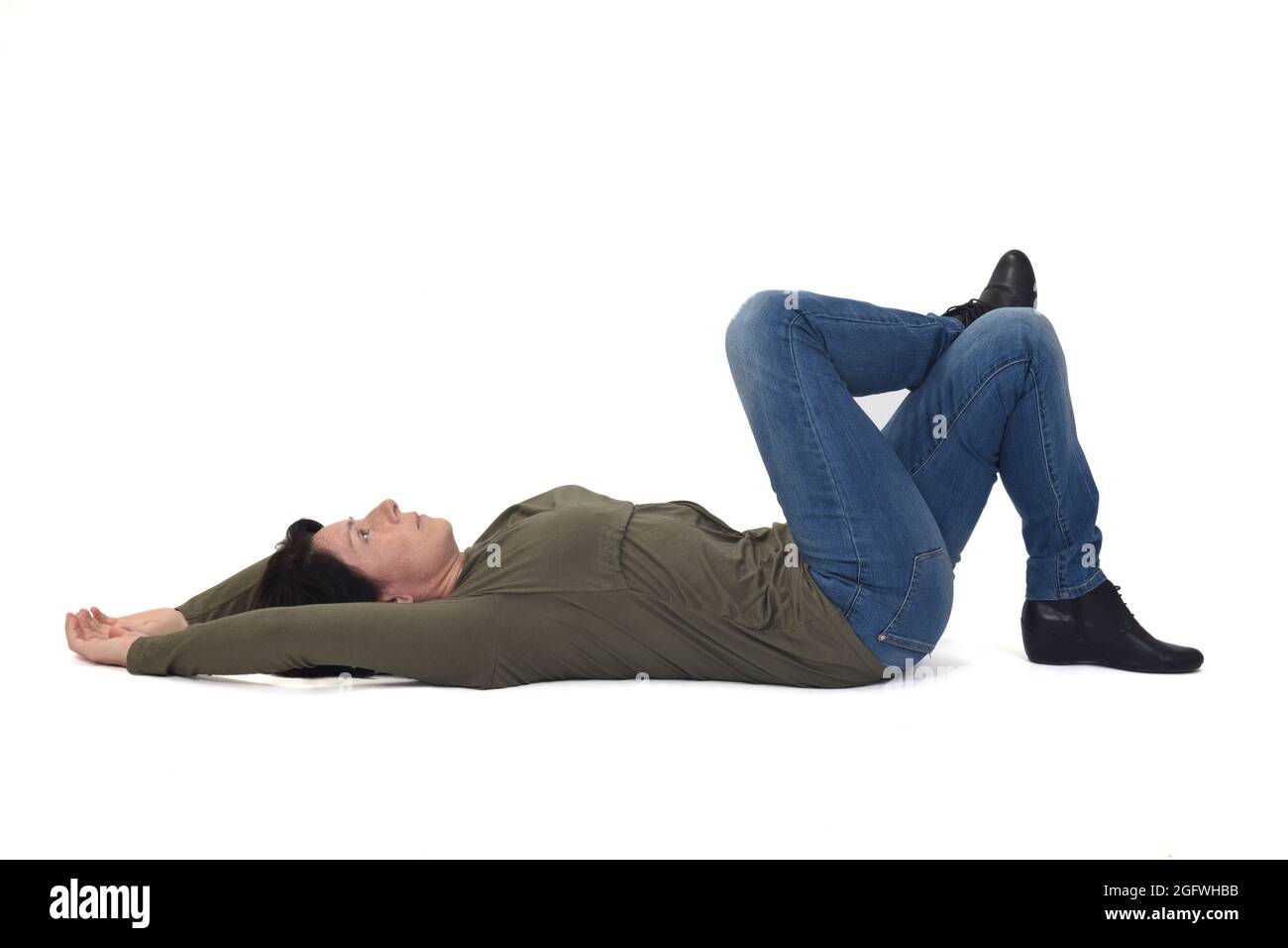 woman lying on the floor looking up and legs crossed on white