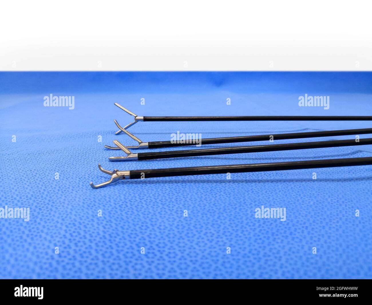 Laparoscopic Surgical Instrument Tip In Blue Background. Selective Focus To Grasper Forceps Tip Stock Photo