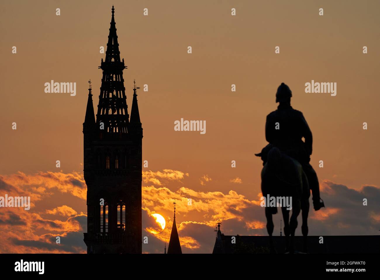 Telephoto lens shot of stunning sunset behind the University of Glasgow tower with the statue of Lord Roberts of Kandahar foreground. Stock Photo