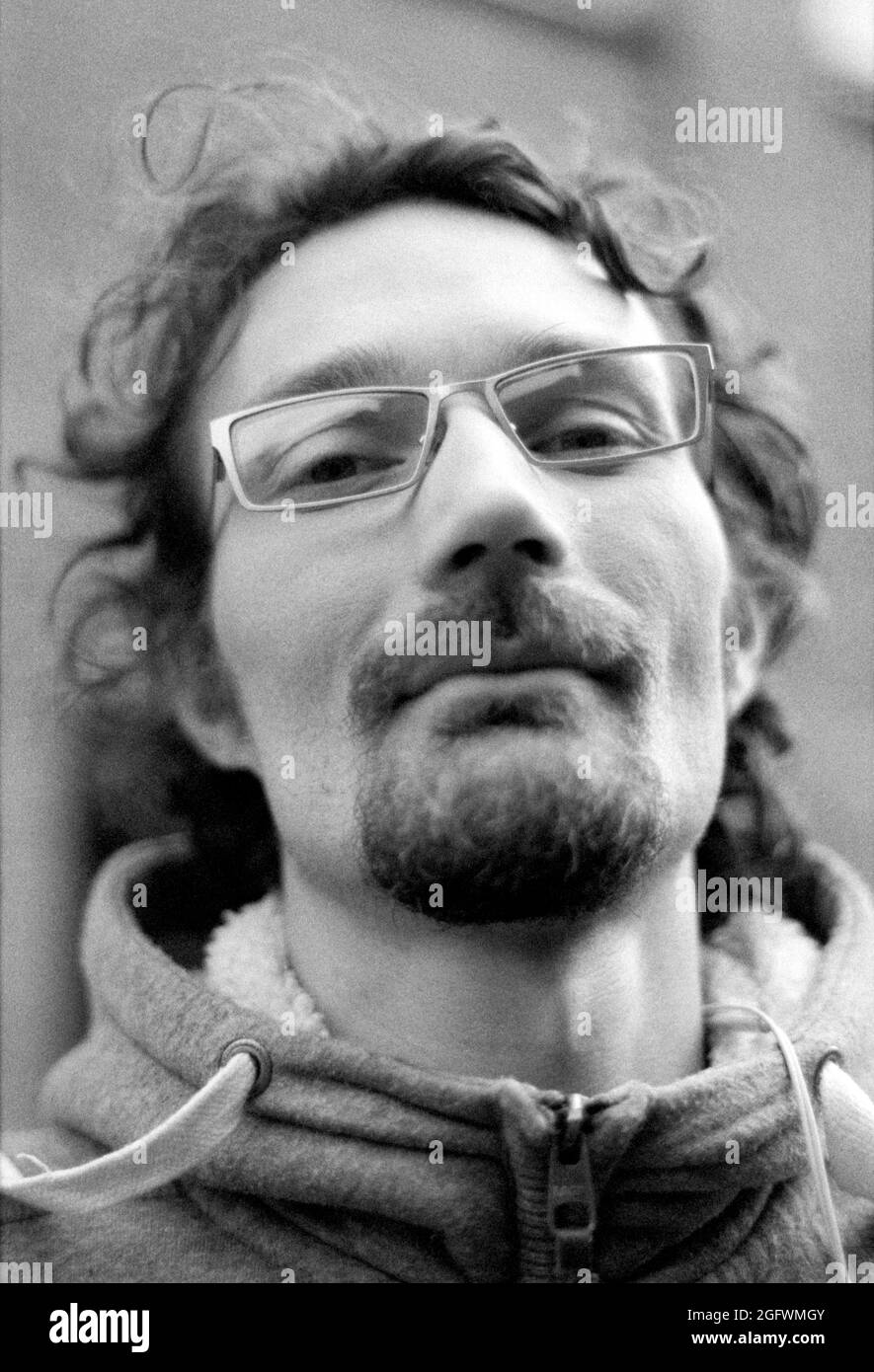 Tilburg, Netherlands. Black & White portrait of an adult, Peter caucasian male wearing glasses and walking the streets down town. Shot on Analog Film. Stock Photo