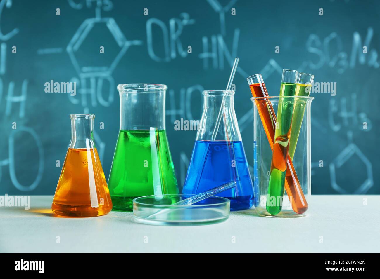 Test tubes and flasks on color background Stock Photo - Alamy