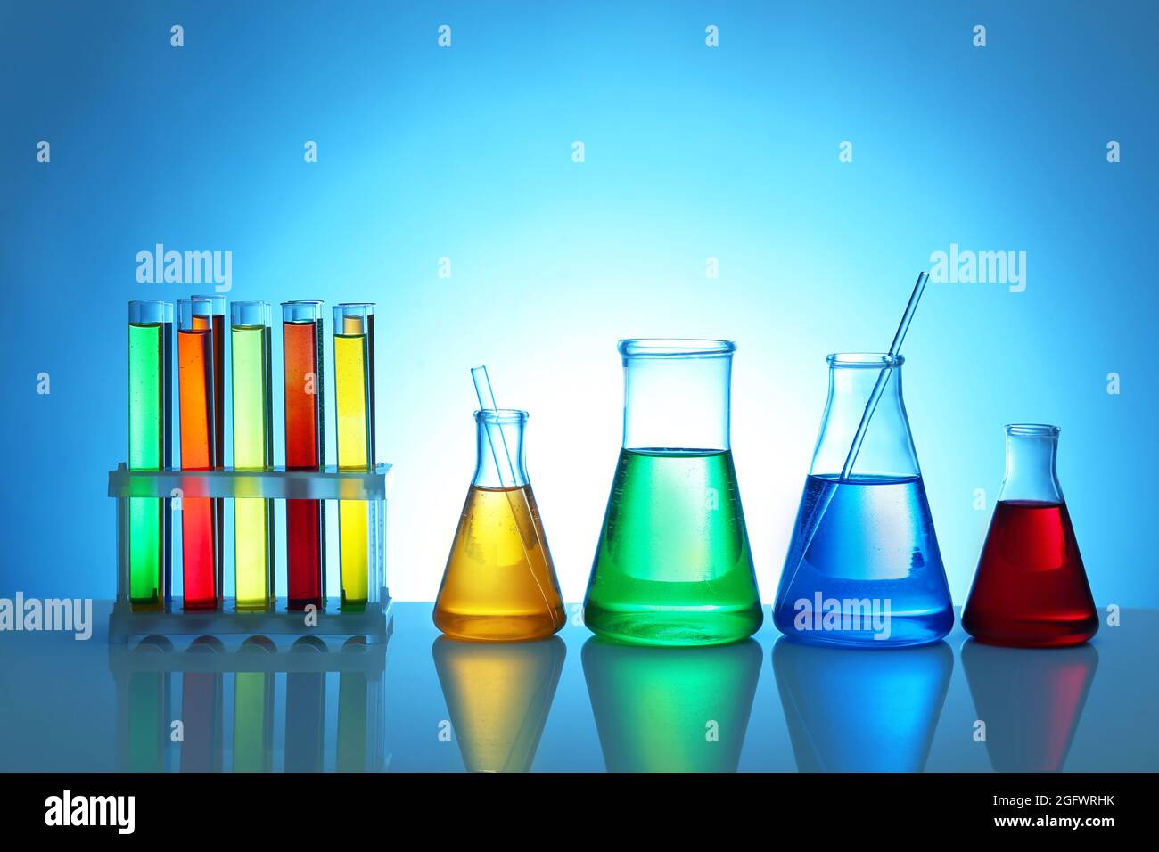 Test tubes and flasks on color background Stock Photo - Alamy