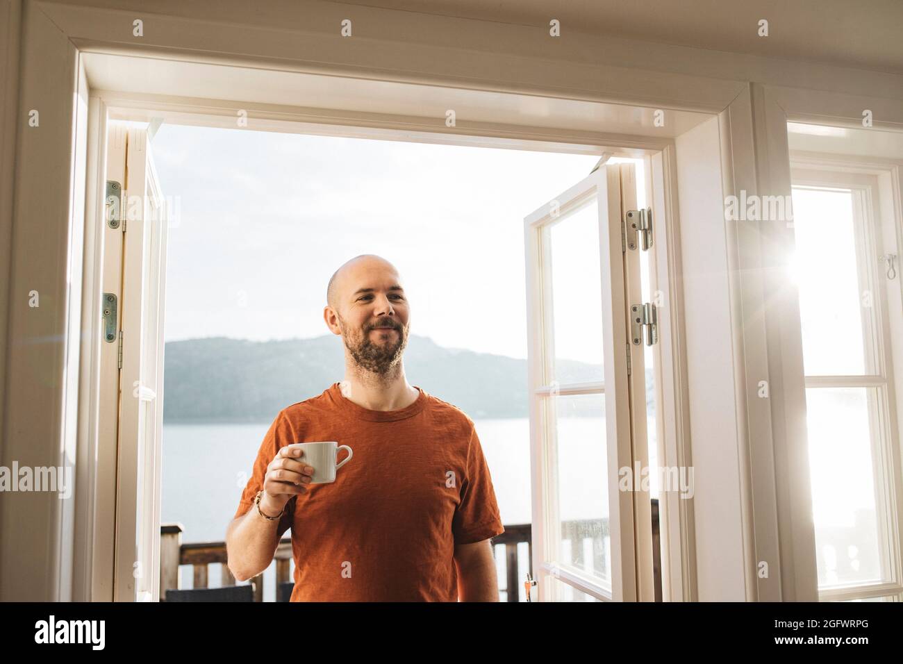 Smiling man holding mug with coffee Stock Photo