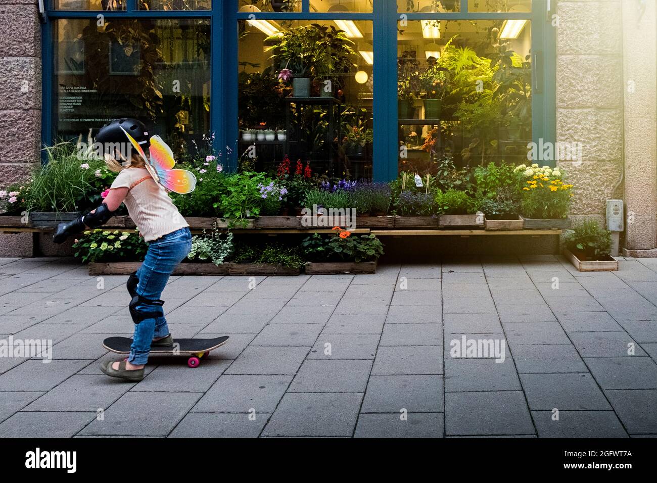 Girl skateboarding on sidewalk Stock Photo