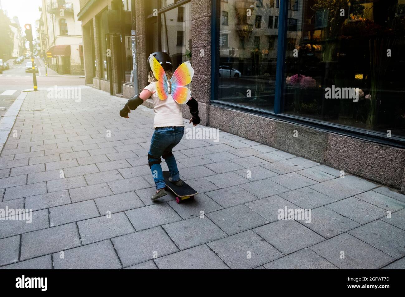 Girl skateboarding on sidewalk Stock Photo