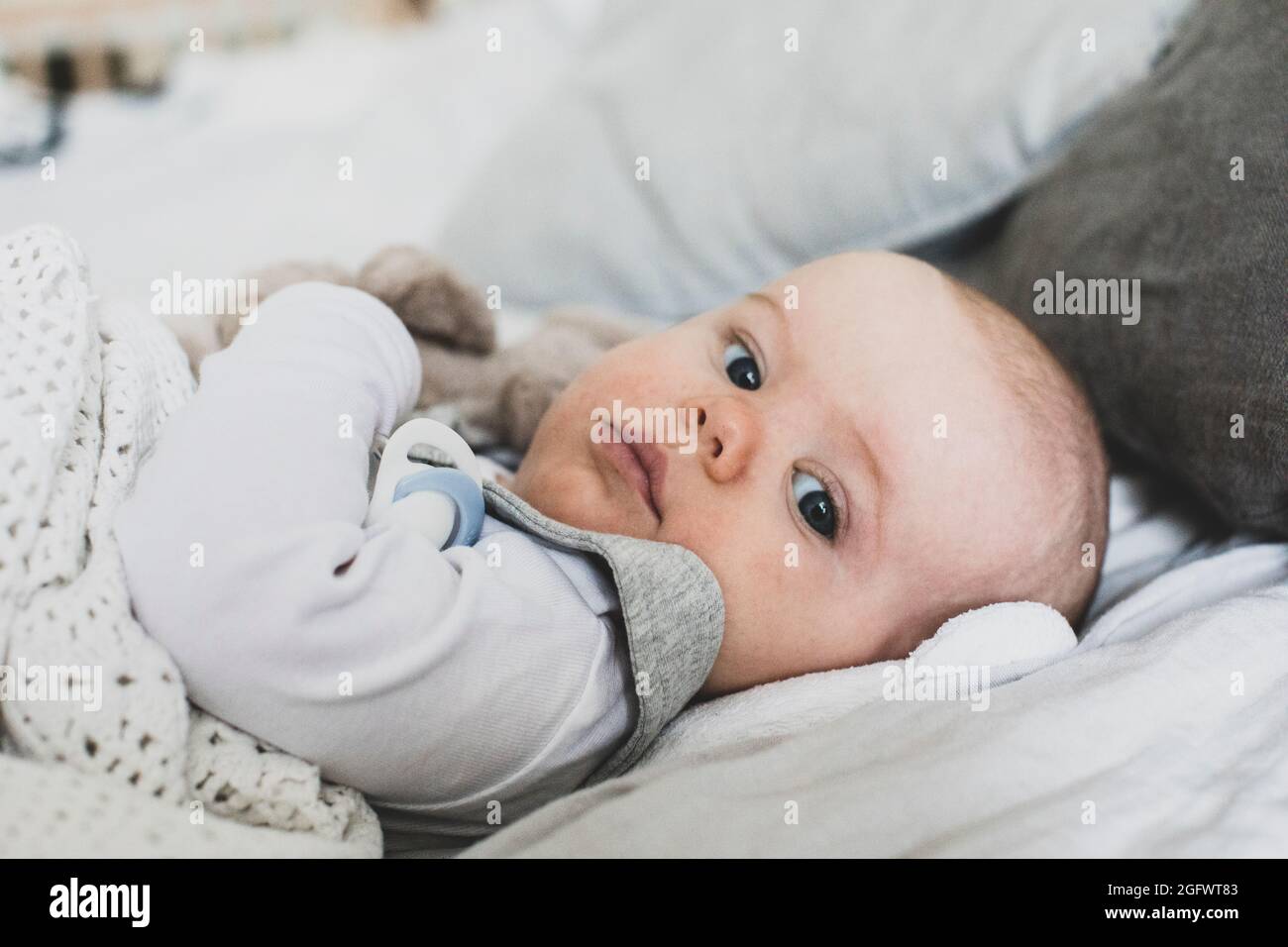 Baby lying in bed Stock Photo