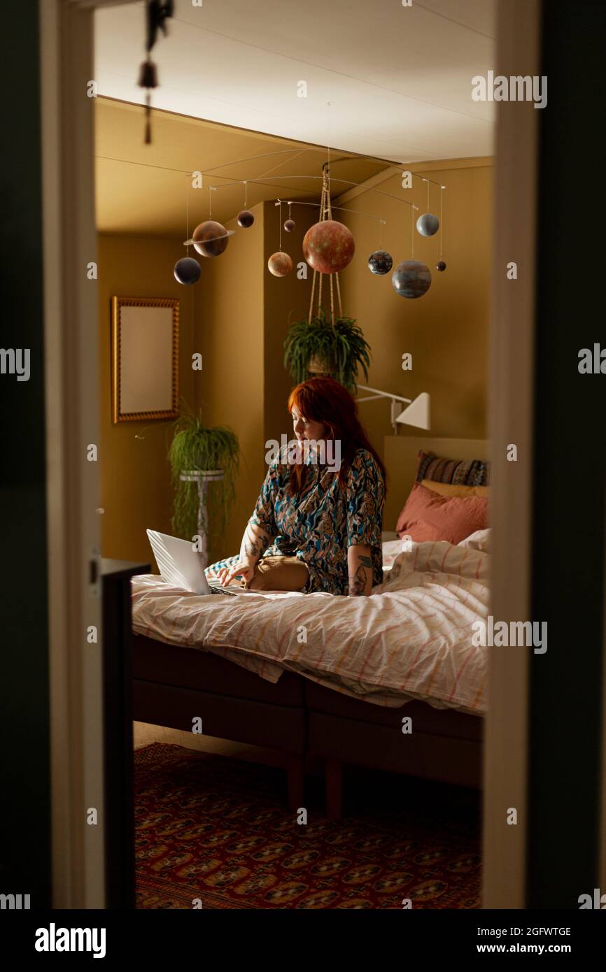 Woman on  bed using laptop Stock Photo