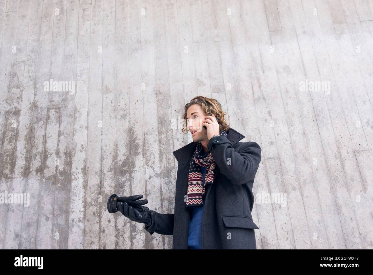 Young man in winter clothing talking on phone Stock Photo