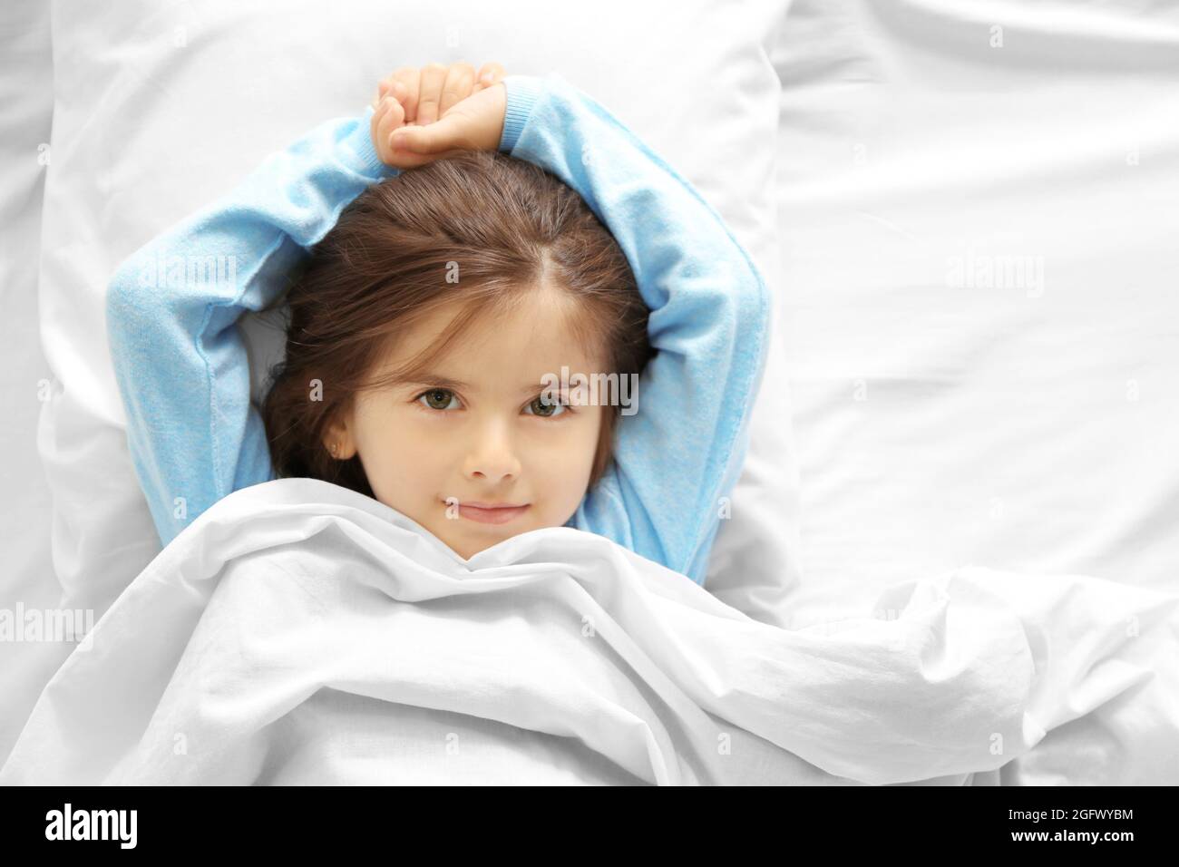 Funny little girl lying in bed at home Stock Photo Alamy