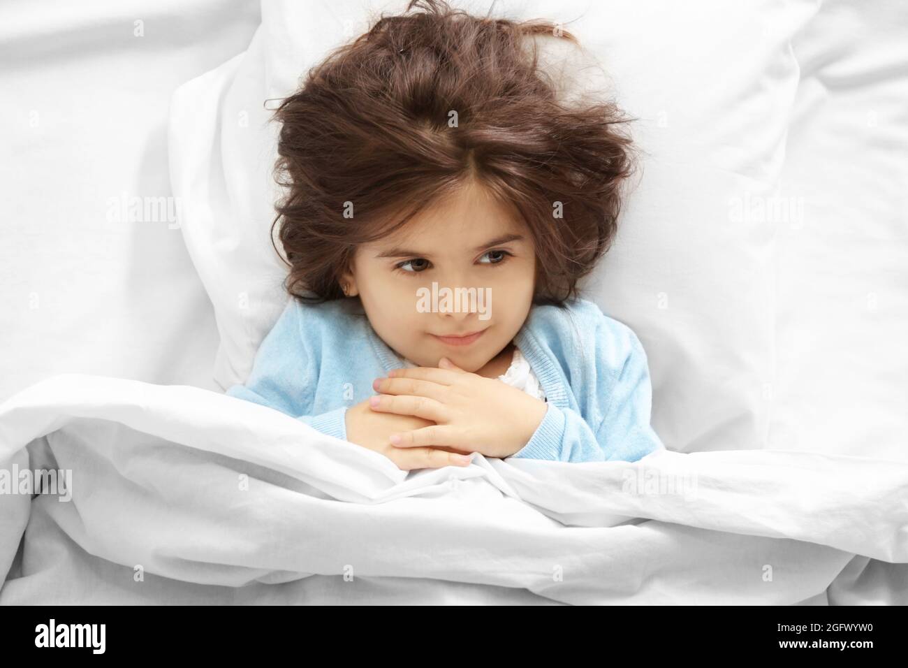 Funny little girl lying in bed at home Stock Photo Alamy