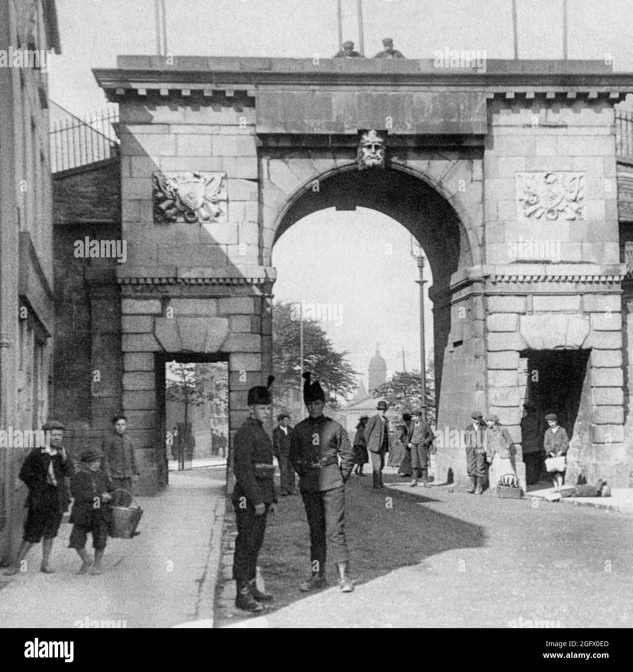 An early 20th century  view of the Bishops Gate in the walls of Derry City aka Londonderry City, in Northern Ireland.  The  original gate was replaced in 1789 by a triumphal arch to mark the first centenary of the closing of the gates by The Apprentice Boys of Derry. The architect was H.A. Baker, with the sculpted heads representing the River Foyle (external) and the River Boyne(internal) designed by Edward Smyth, who had sculptured the thirteen riverine heads on the Dublin Custom House in 1784. Stock Photo
