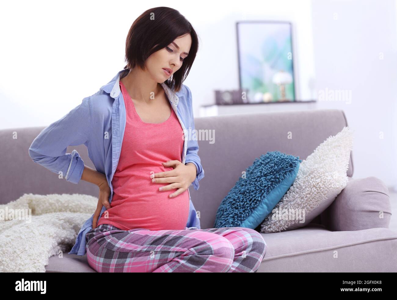 Young pregnant woman suffering from backache at home Stock Photo Alamy