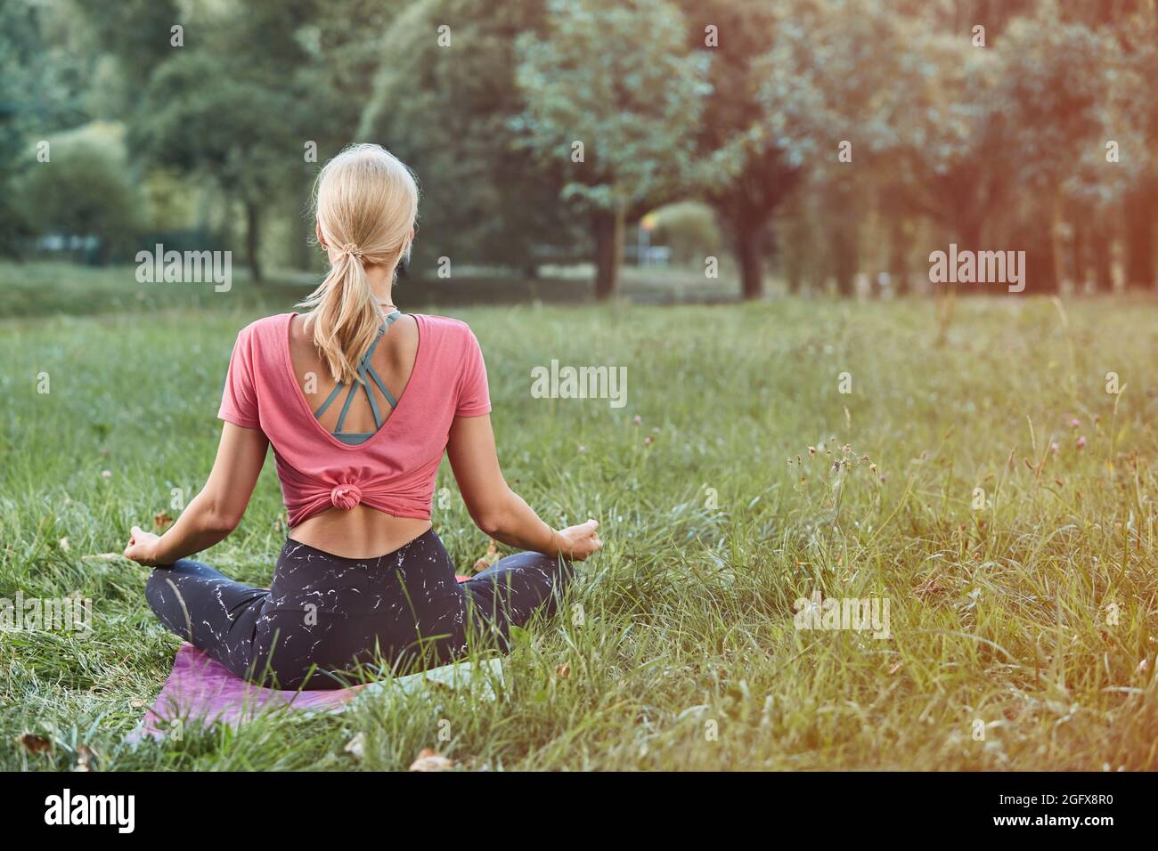 young Sport blond woman yogini practice yoga exercise in park on ...