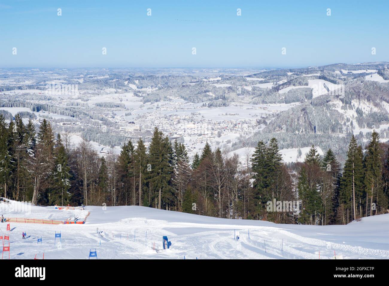 OBERSTAUFEN, GERMANY - 29 DEC, 2017: Beautiful view of the snowy winter resort Oberstaufen with a ski slope in the foreground in the Bavarian Alps Stock Photo