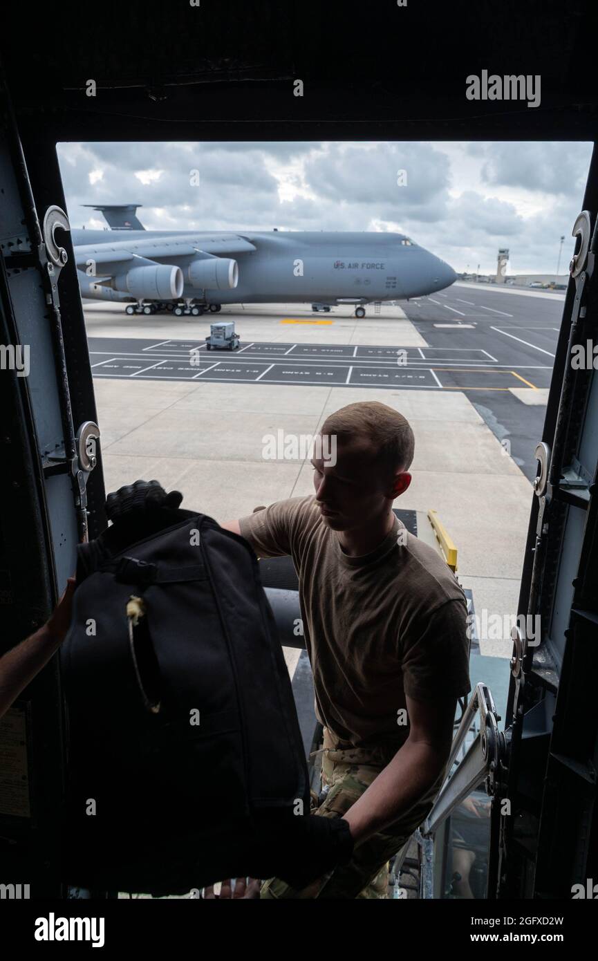 Staff Sgt. Hunter Barron, 9th Airlift Squadron loadmaster, loads luggage into a C-5M Super Galaxy before takeoff to Hamid Karzai International Airport, Afghanistan from Dover Air Force Base, Delaware, Aug. 16, 2021. Air Mobility Airmen play a key role in facilitating the safe departure and relocation of U.S. citizens, Special Immigration Visa recipients, and vulnerable Afghan populations from Afghanistan. (U.S. Air Force photo by Senior Airman Faith Schaefer) Stock Photo