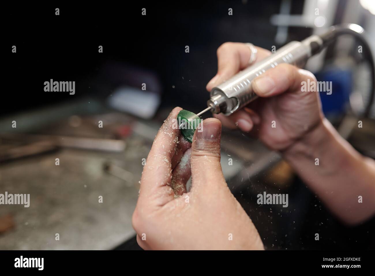 Close-up of unrecognizable female jeweler shaping ring using polishing tool in workshop Stock Photo