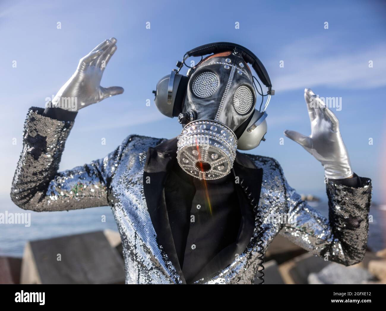 man with sparkling gas mask dancing by the sea Stock Photo