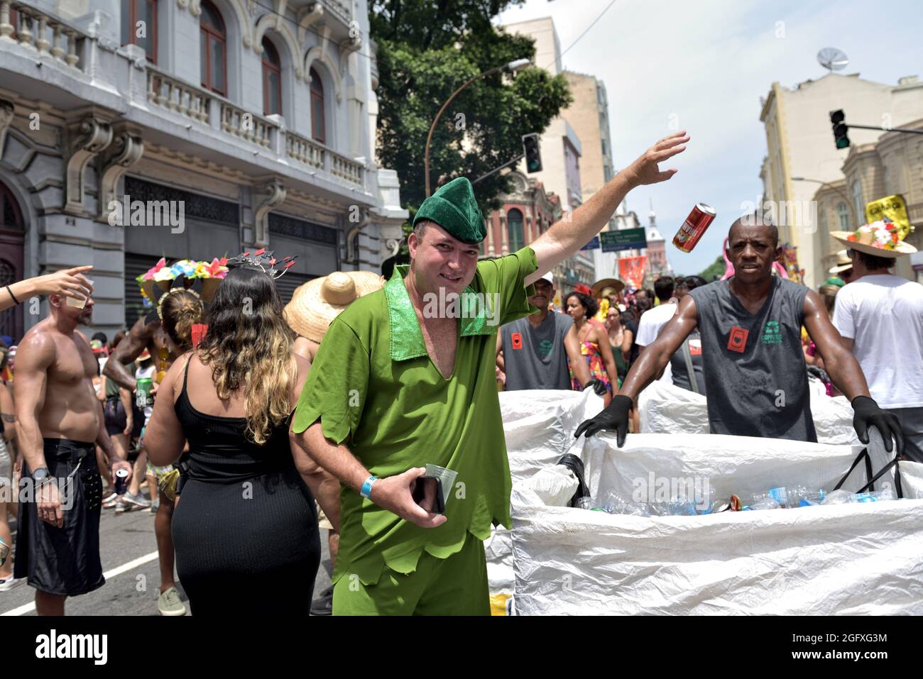 February 16, 2020: Can and plastic bottles recycling program during street Carnival parades in Rio de Janeiro.Man in costume contributes to recycling. Stock Photo