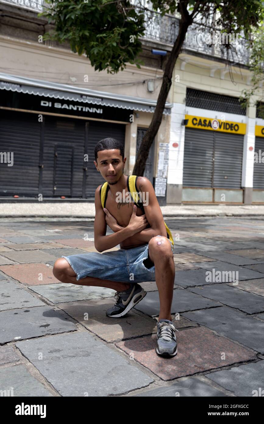 Americas, Brazil–February 16, 2020: Boy wearing shorts and sneakers poses for the camera after a street Carnival party held in central Rio de Janeiro Stock Photo
