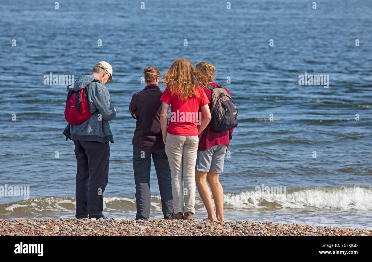 Fortrose Bay, Ross and Cromarty, Scotland, UK weather. 27th August 2021. Sunny after  a misty start for these potential Dolphin watchers, however unfortunately the Dolphins had a day off and did not arrive for the many photographers and tourists who turned up at the popular viewing areato see them. Credit: Arch White/Alamy Live News Stock Photo