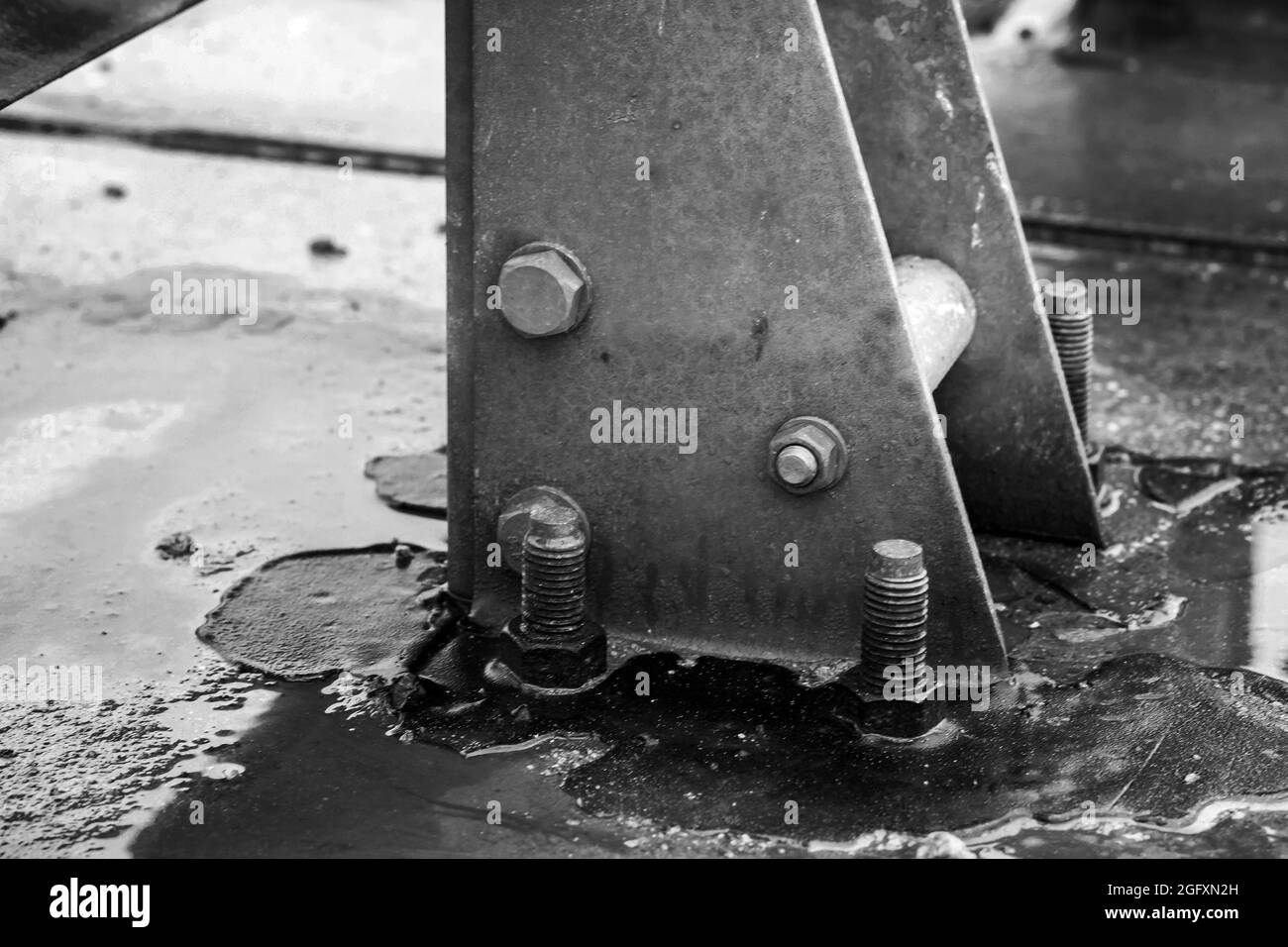 Abstract industrial wet gray metal structures connected with bolts, close-up  black and white photo with selective soft focus Stock Photo