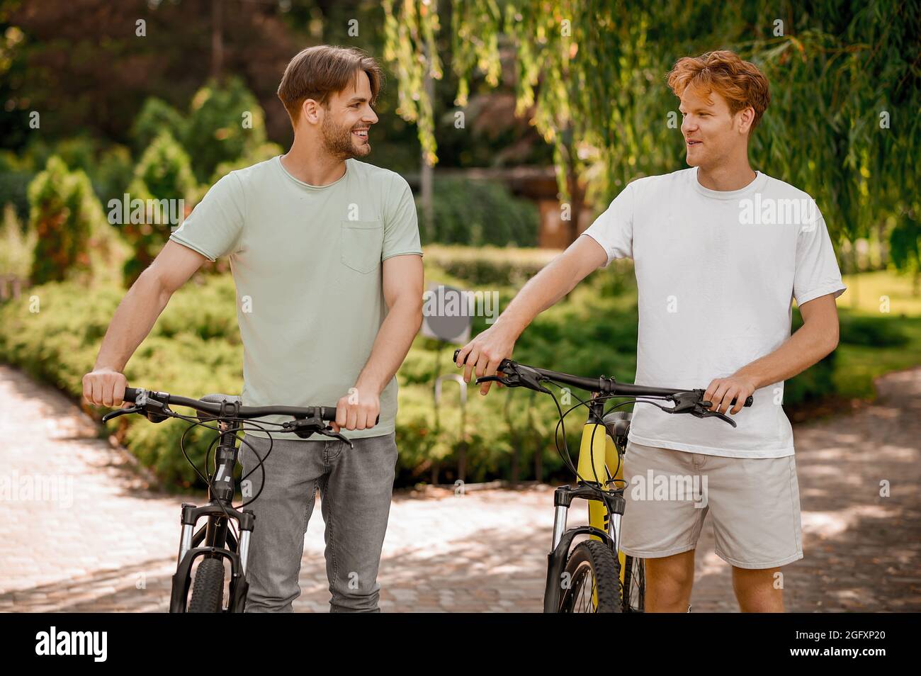 Cheerful man and his pal standing in a local park Stock Photo