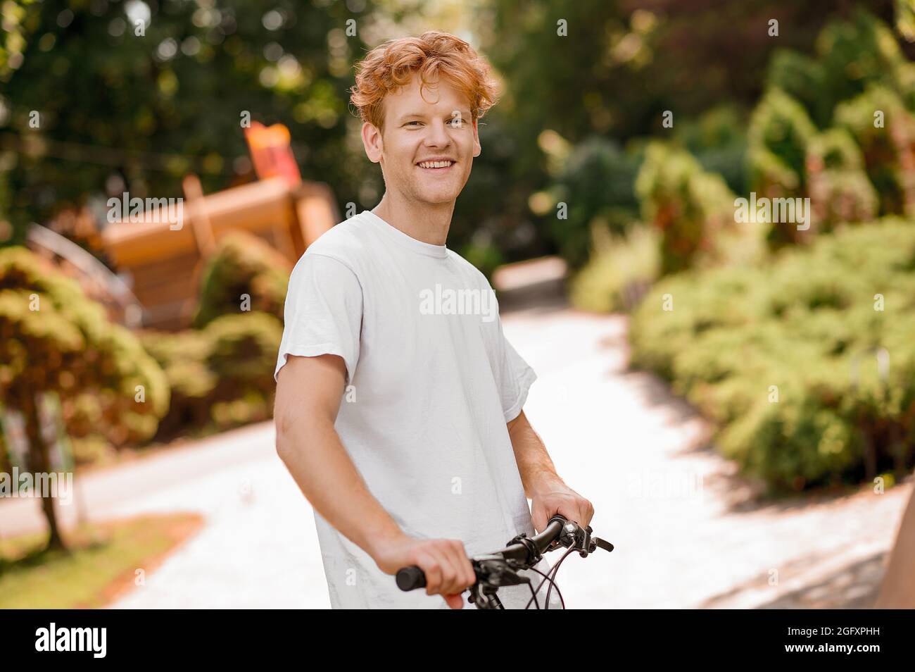 High-spirited athletic Caucasian guy with his bicycle Stock Photo