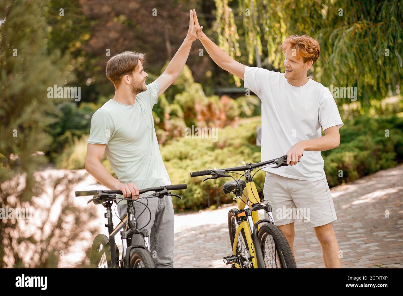 Two pleased sporty pals greeting each other Stock Photo