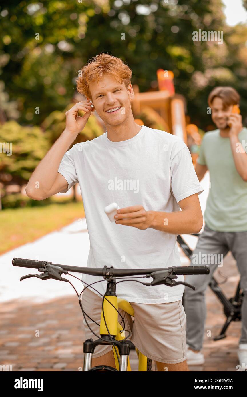 Two bicyclists with their gadgets standing outdoors Stock Photo