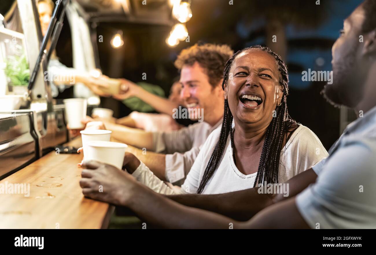 Happy multiracial people buying meal from street food truck market - Modern business and take away concept Stock Photo