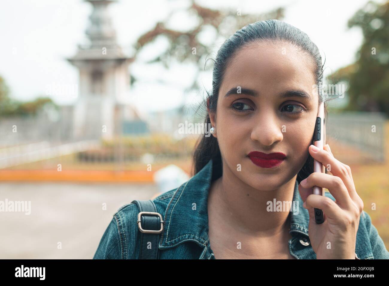 Young Latin female talking on the phone Stock Photo - Alamy