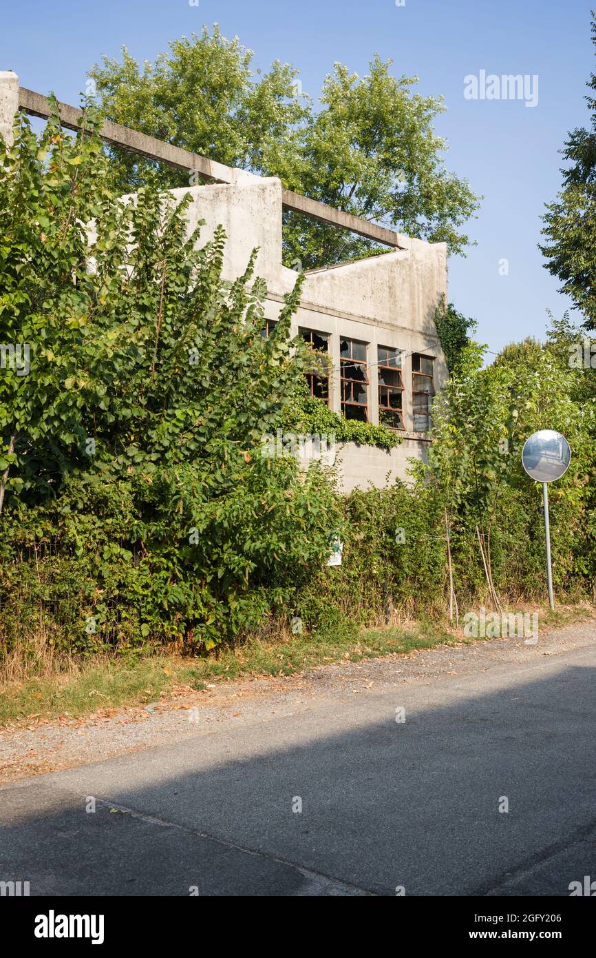 An abandoned, ruined and overgrown 1950s factory in Treviglio in Lombardy / Lombardia, Italy. Stock Photo