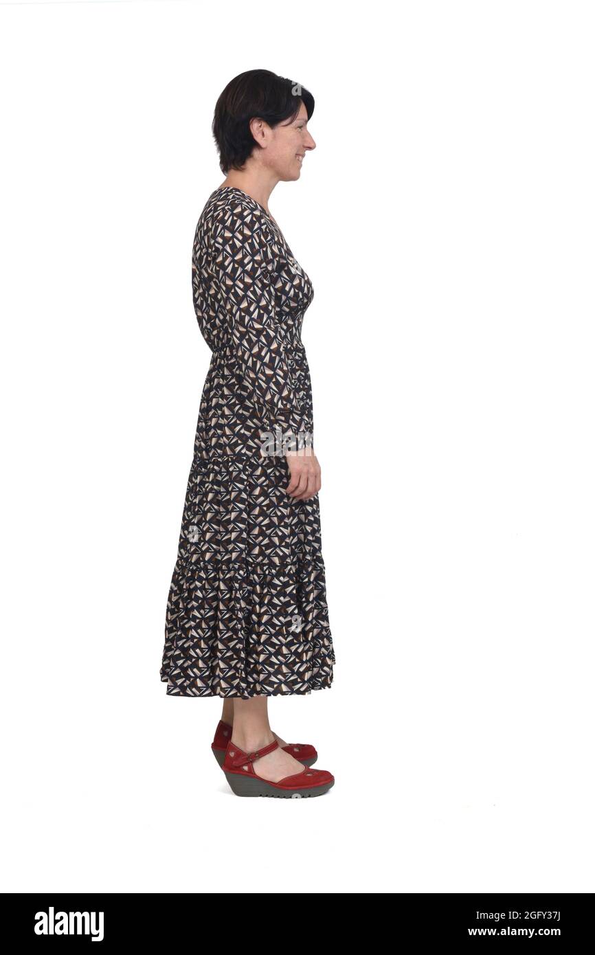 side view of a full portrait of a woman with long dress smiling and looking on white background Stock Photo