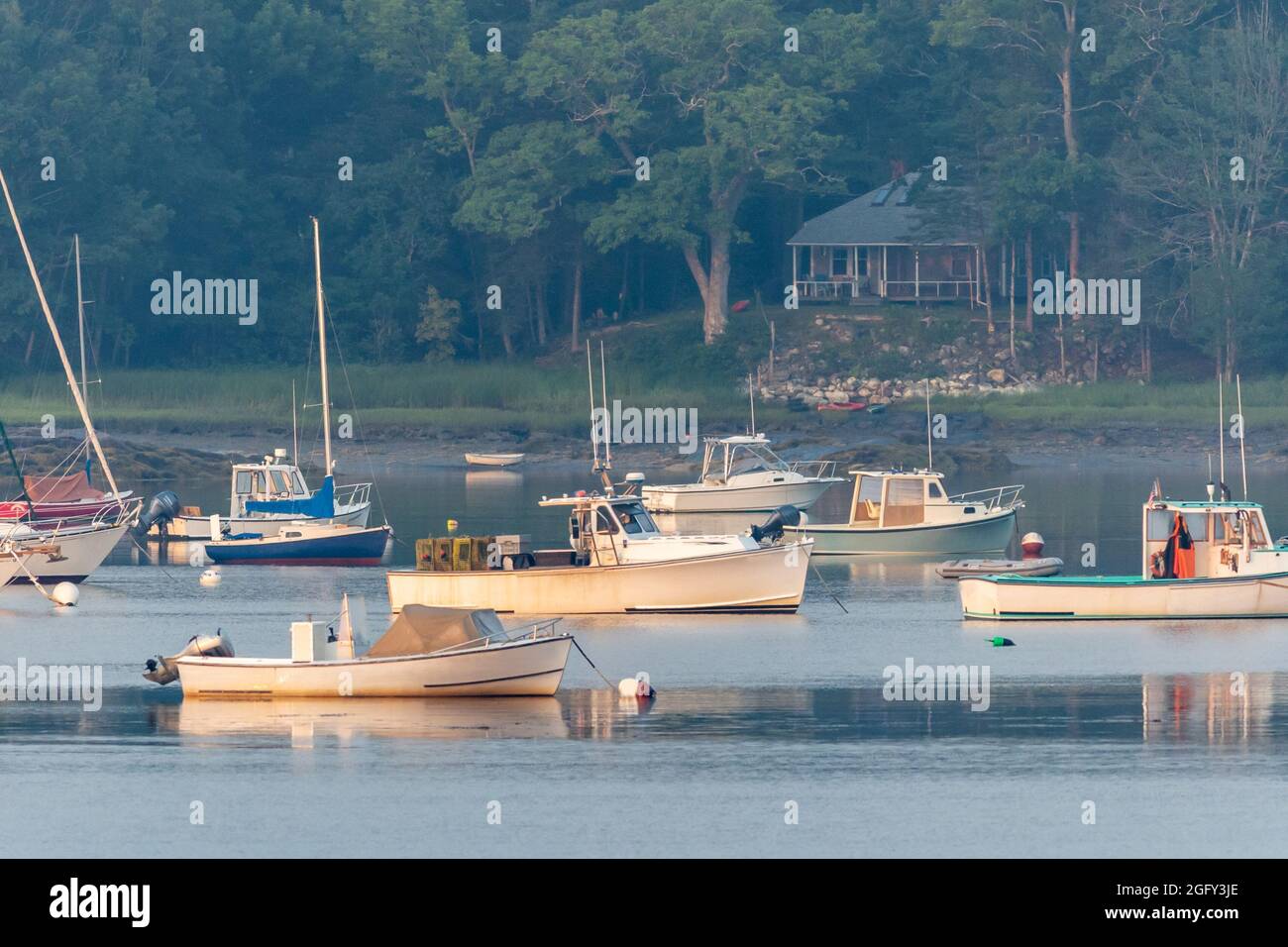 Lobster boats and skiffs on a misty calm morning in Round Pond Maine Stock Photo