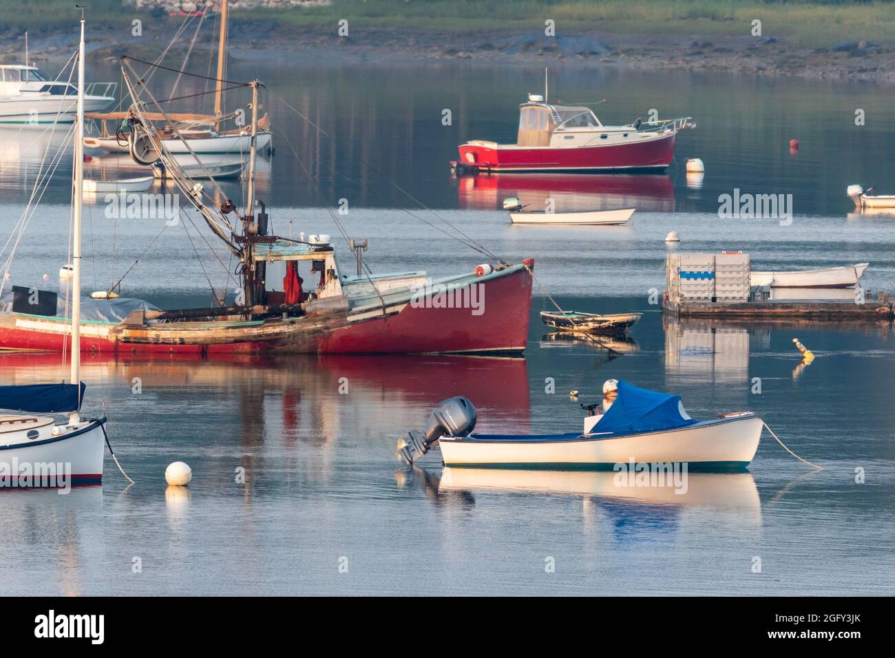 Lobster boats and skiffs on a misty calm morning in Round Pond Maine Stock Photo
