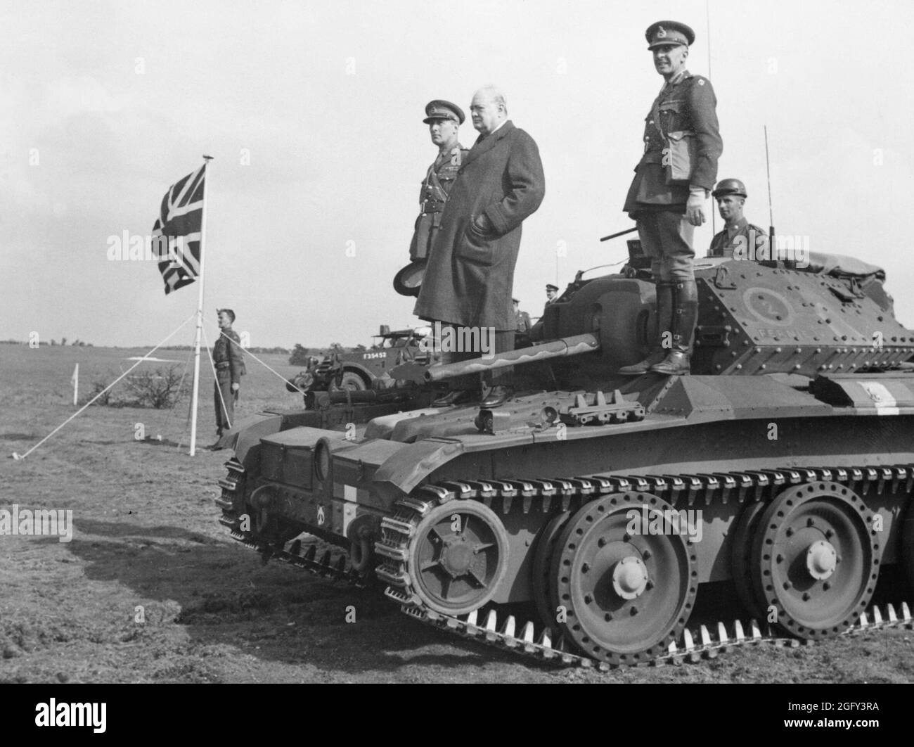 Winston Churchill with Major-General Brian Horrocks on a Covenanter tank of 4th/7th Royal Dragoon Guards, 27th Armoured Brigade, to take the salute at an inspection of 9th Armoured Division near Newmarket, Suffolk, 16 May 1942. Stock Photo