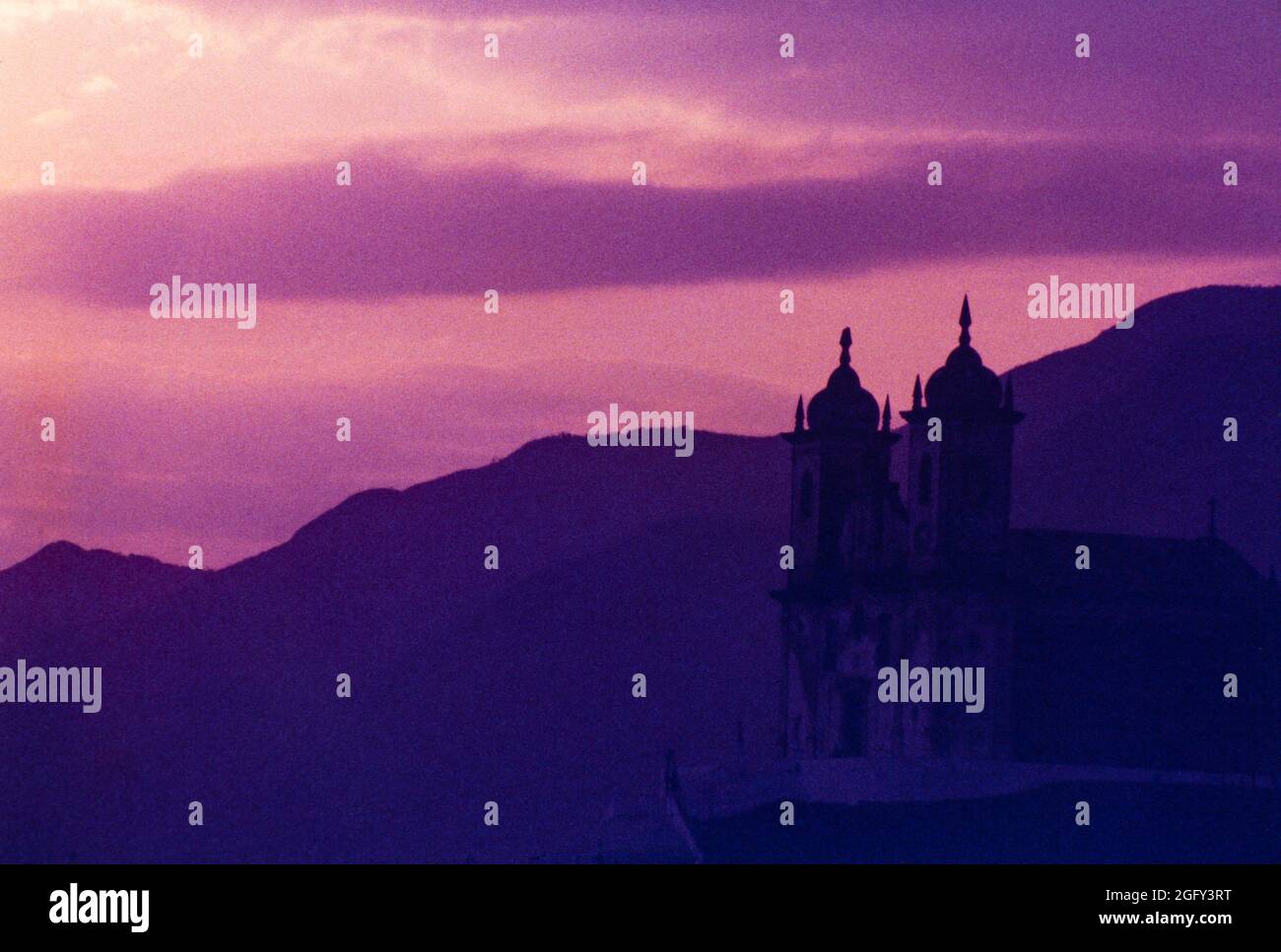 Silhouette of catholic church at twilight - Ouro Preto is a former colonial mining town located in the Serra do Espinhaço mountains and designated a World Heritage site by UNESCO because of its outstanding Baroque Portuguese colonial architecture. Stock Photo