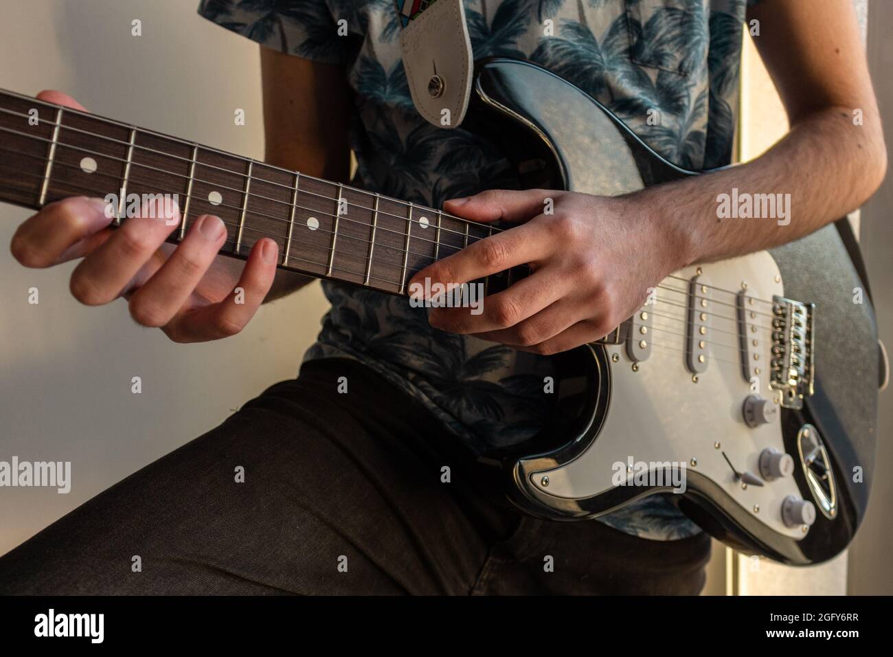 Closeup shot of a young male hands practicing playing guitar Stock Photo