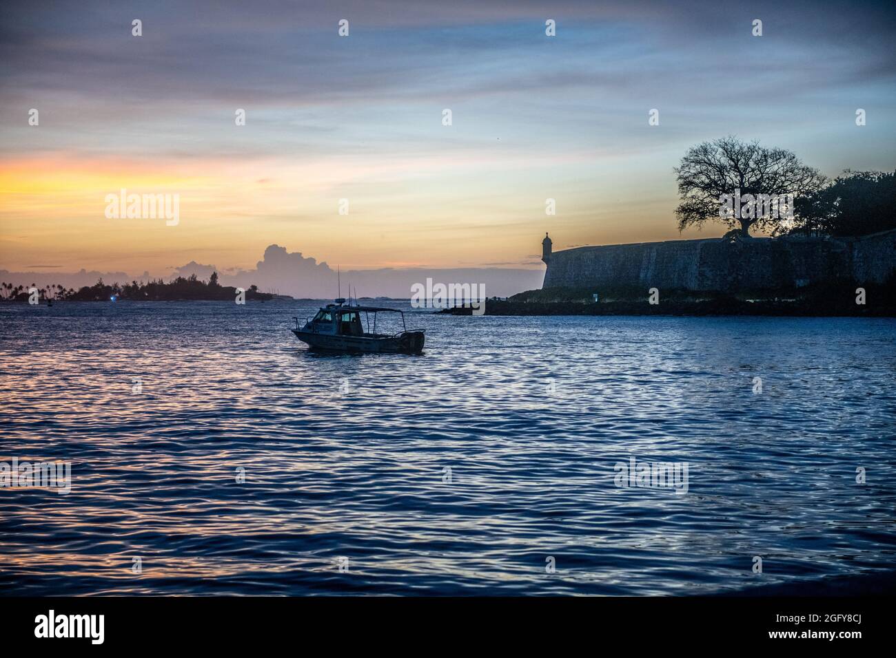 A boat pulling away from San Juan at sunset - Puerto Rico Stock Photo
