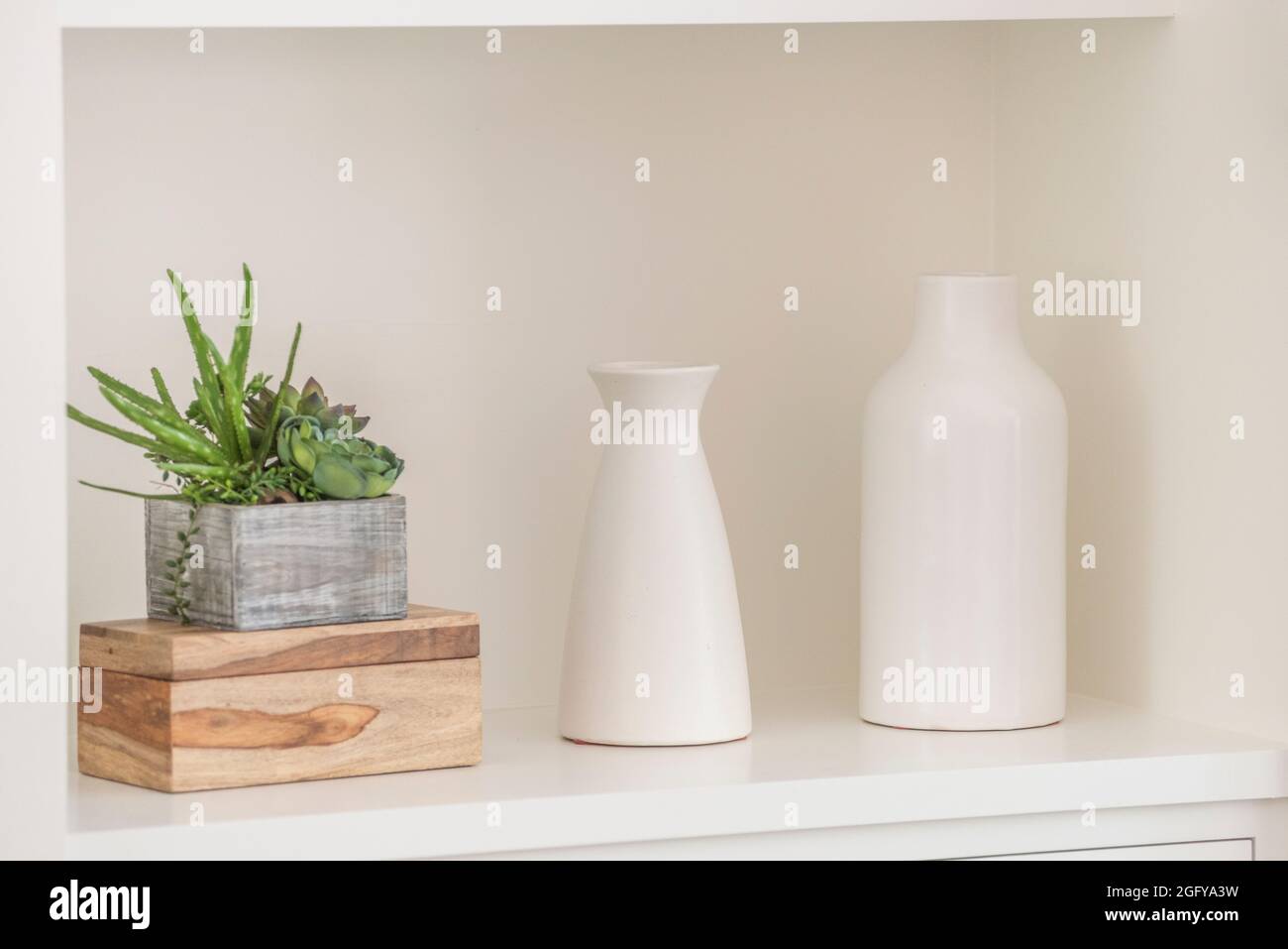 Modern interior photo of two white vases and cactus plant in a white alcove. Stock Photo
