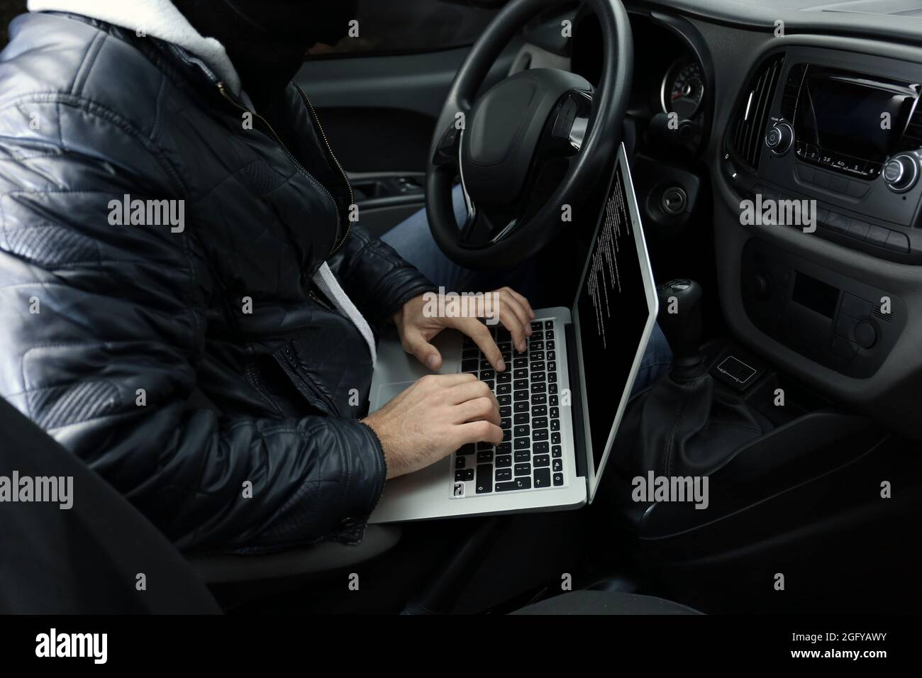 Car thief hacking security systems with laptop computer Stock Photo Alamy