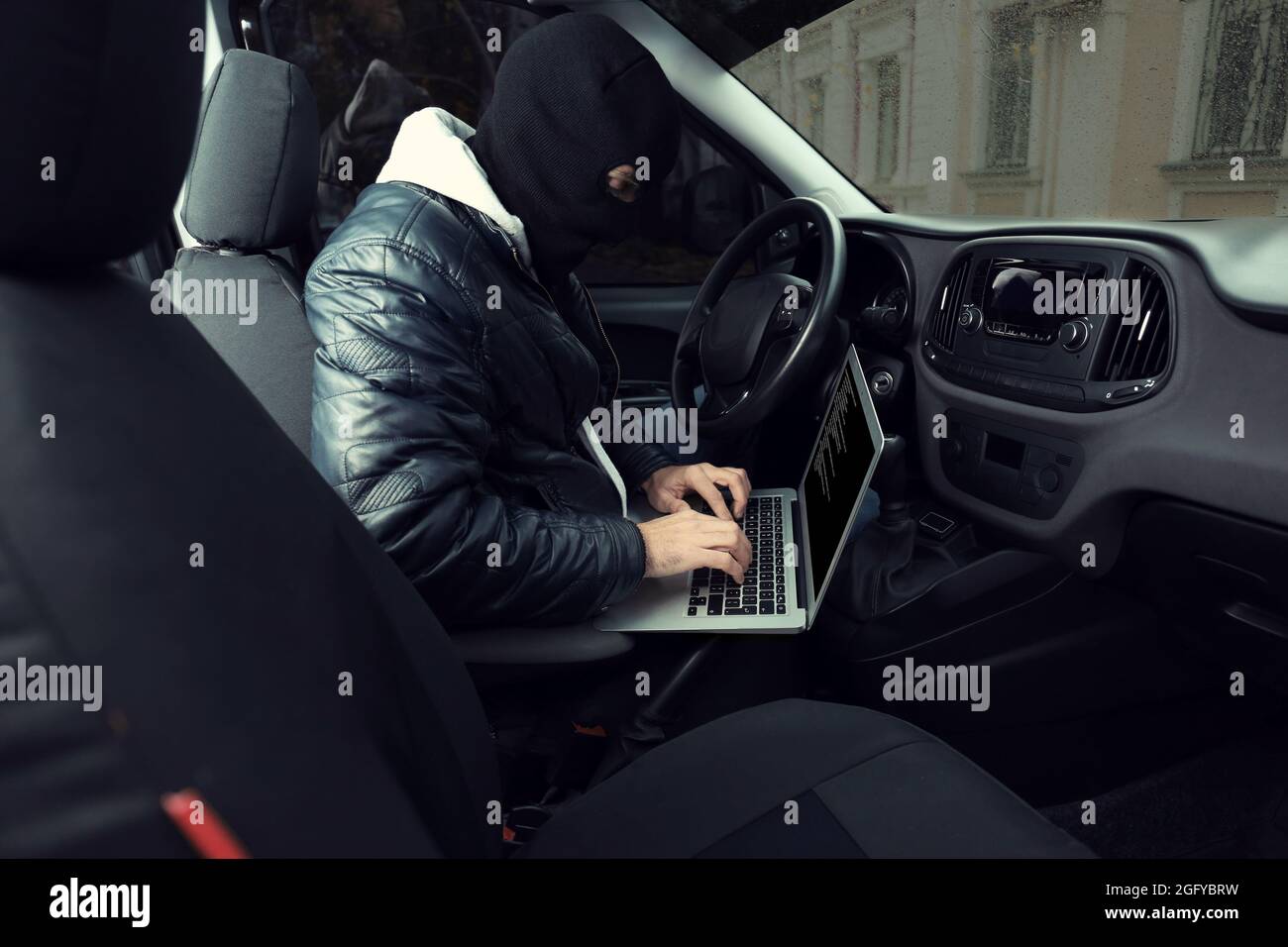 Car thief hacking security systems with laptop computer Stock Photo Alamy